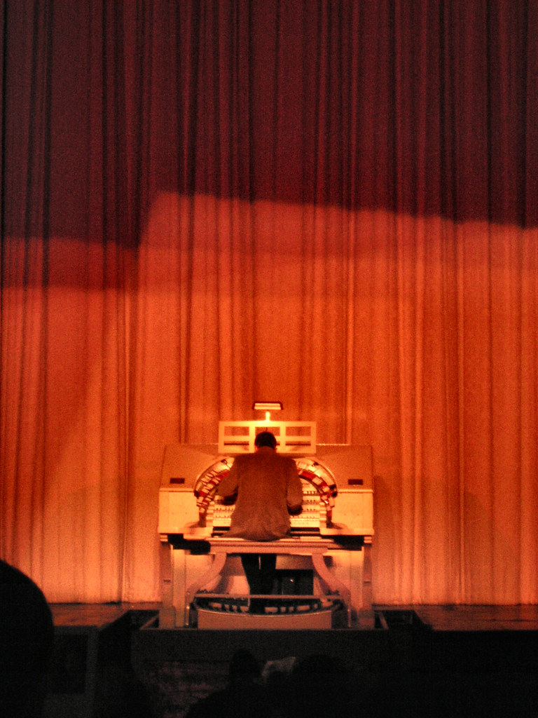 An organist seated at the console of a church organ