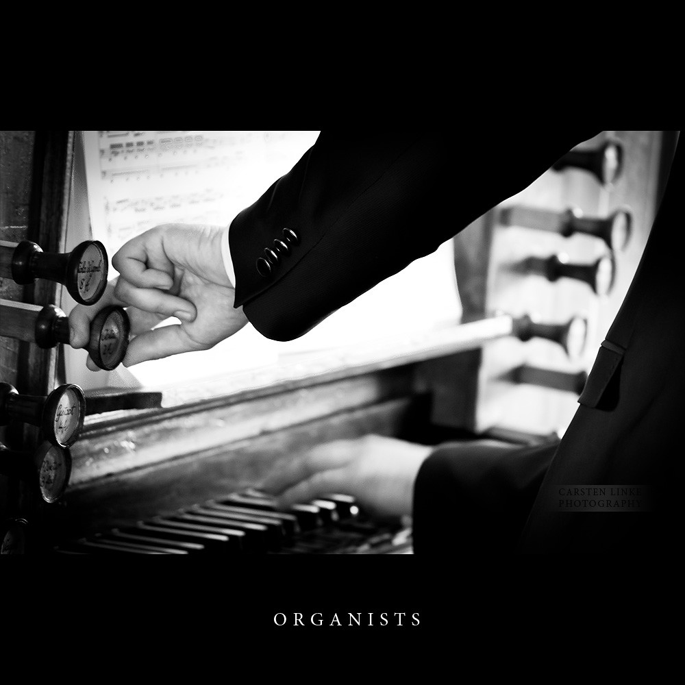 Organists gathered around a church organ console